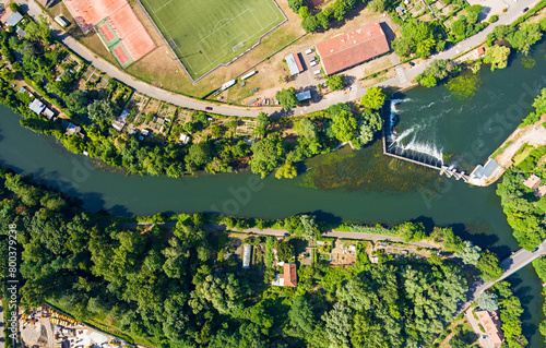 Strasbourg, France. Football field and garden plots. Riffle with a dam on the Ill River. Panorama on a summer day. Sunny weather. Aerial view photo
