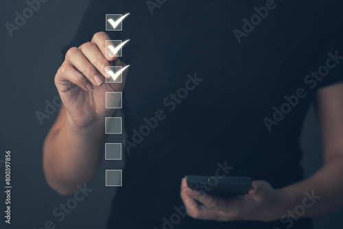 Businessman uses his mouth to check boxes in the document list Concept of online verification form Checklist process sequence The business reviews the job details and ticks the evaluation.