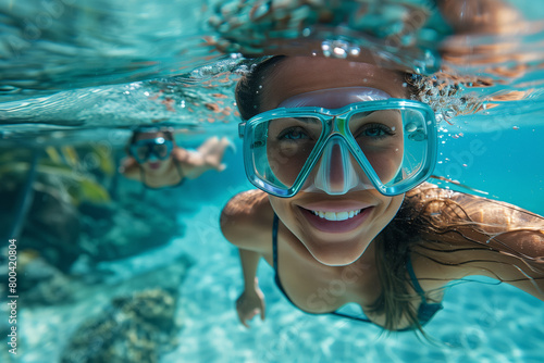 A young girl captures a selfie underwater with crystal clear views, accompanied by vibrant coral reefs, ecotourism and in aquatic ecosystems caring for marine conservation. photo