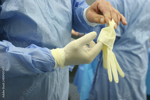  Hospital. Operating room. Surgeon putting on his gloves.