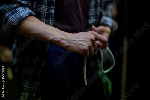 Close-Up of a Man Tying Knot in Dim Light photo