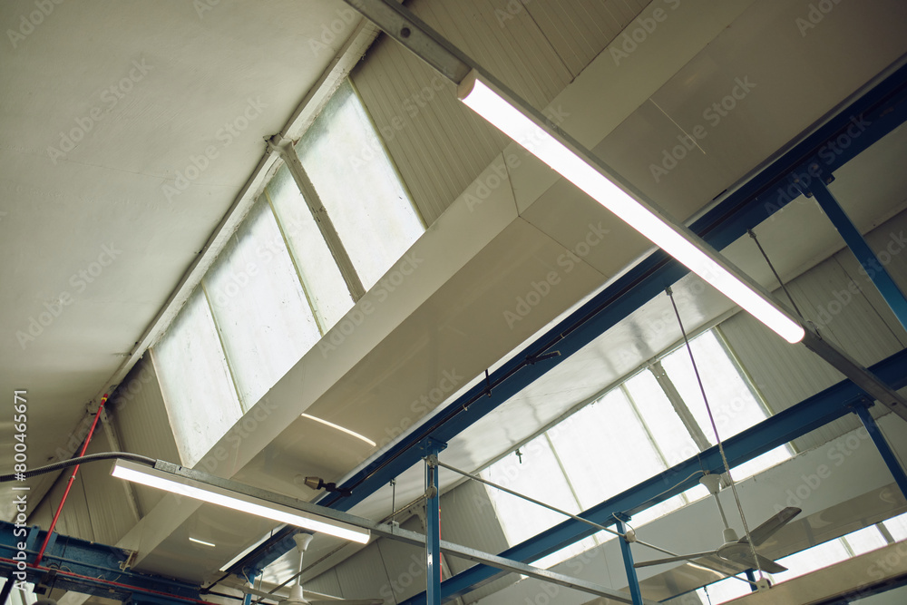 Fototapeta premium A rustic old factory skylight window in an industrial manufacturing factory setting. Retro and vintage workplaces. Window and natural daylight light source from the sun.