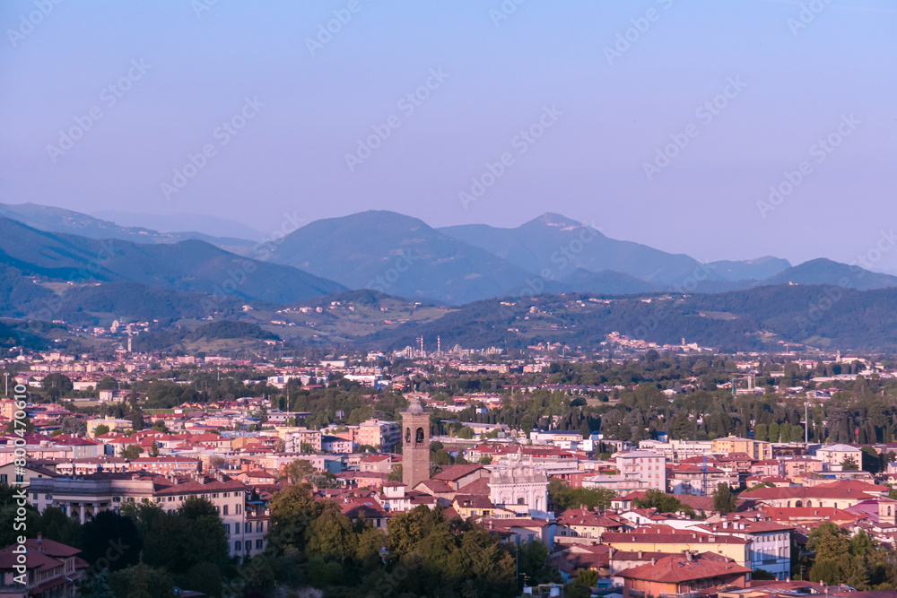 Aerial view of historic medieval walled city of Bergamo seen from Città Alta (Upper Town), Lombardy, Northern Italy, Europe. Alpine landscape of Italian Alps, historical buildings and the towers