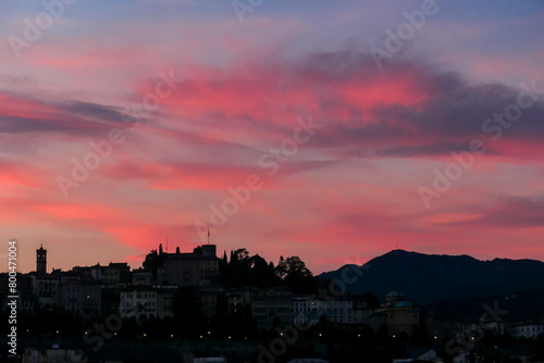 Scenic sunset view of tower of  church Chiesa di Sant Alessandro della Croce the town of Bergamo  Lombardy  Northern Italy  Europe. Romantic atmosphere in historical old town. Silhouette of buildings