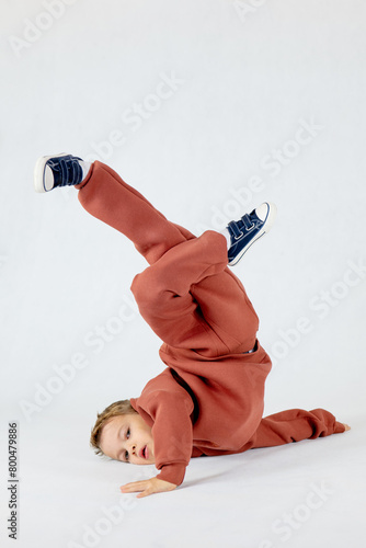 A little boy in a breakdance position. A little boy is breakdancing.