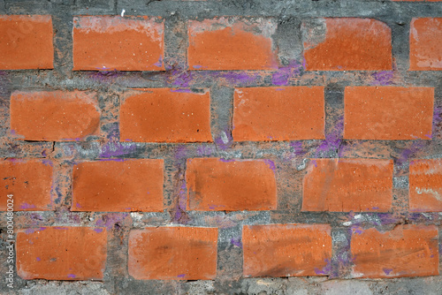 Red bricks in concrete wall with as background front view close up horizontal view