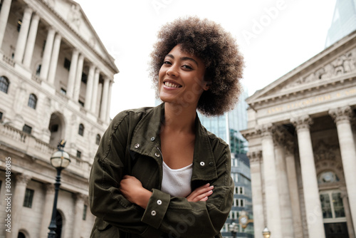 Happy curly woman looking at camera outdoors.