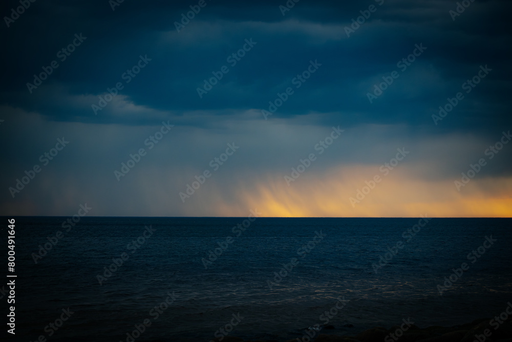 Dark ominous sea with sunset on the horizon in spring. Soft selective focus. Artificially created grain for the picture Dark ominous sea with sunset on the horizon in spring. Soft selective focus. Artificially created grain for the picture
