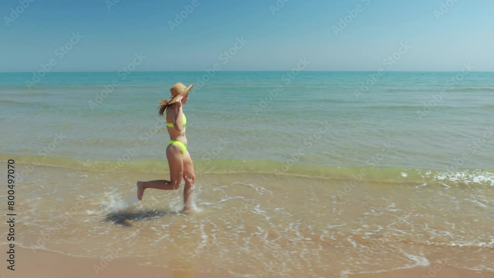 Beautiful woman wearing swimsuit and sun hat, relaxing walk on tropical paradise beach, happy woman in bikini swimsuit having fun, summer vacation travel. Beautiful woman wearing swimsuit and sun hat, relaxing walk on tropical paradise beach, happy woman in bikini swimsuit having fun, summer vacation travel.