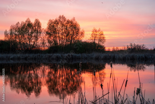 Beautiful dusk with red and blue sky refflected in water surface photo