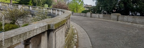 Curved stone balustrade along an empty walkway in a serene park  evoking tranquility  suitable for themes around solitude or European heritage gardens