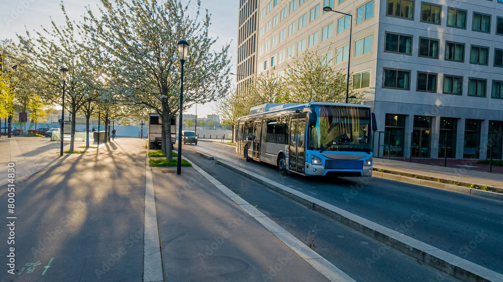 Early morning sunlight casts shadows on an urban street lined with blossoming trees, with a city bus in motion, ideal for public transportation and city life themes