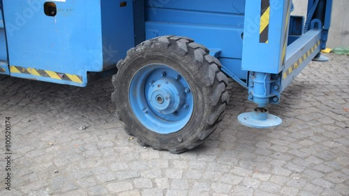 Blue Industrial Lift Truck on Cobblestone Pavement