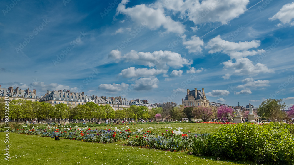 Springtime in Paris with vibrant tulips and greenery in Tuileries Garden, ideal for Easter holiday and travel concepts, with clear blue skies and historic architecture