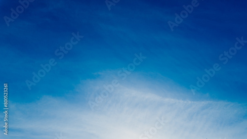Serene blue sky with wispy clouds and a gentle sun, ideal for backgrounds, nature concepts, and World Environment Day promotions photo