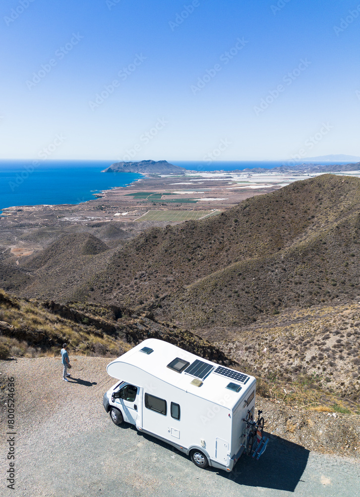Man by his motor home watching nice views from top of the mountain Man by his motor home watching nice views from top of the mountain