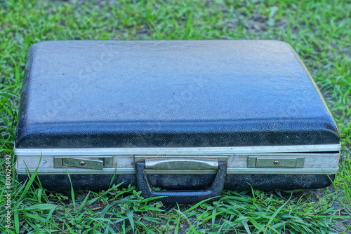 one manual men's black retro square plastic closed document case lies on the green grass during the day outdoors