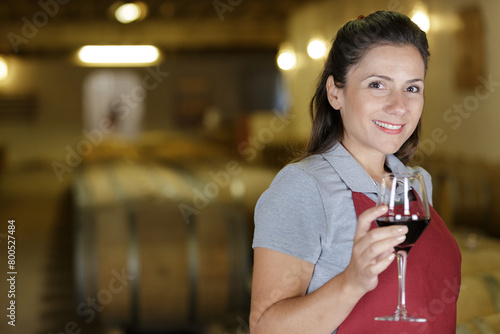 young woman posing with wine from wood in wine house photo