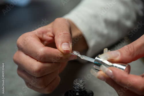 mains d une femme r  alisant sa manucure avec des capsules    coller sur ses ongles 