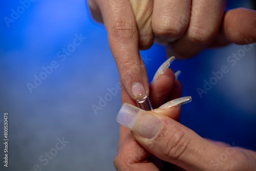 mains d une femme r  alisant sa manucure avec des capsules    coller sur ses ongles 