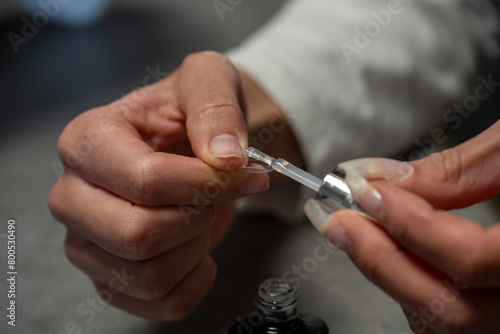 main d'une femme posant des capsules sur ses ongles avec de la colle forte photo
