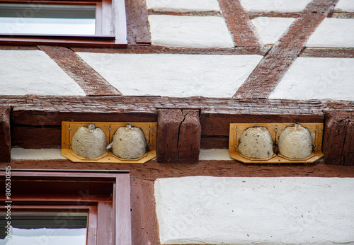 Nests with small swallows under a wooden beam of the house.