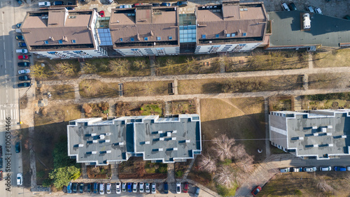 Drone photography of multistory houses, streets and sidewalks in a city during spring day
