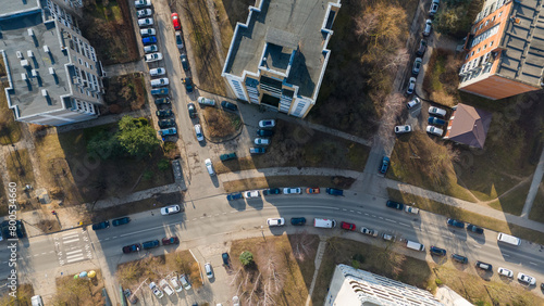 Drone photography of multistory houses, streets and sidewalks in a city during spring day