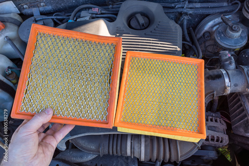 A new and old dirty car engine air filter in the hands of an auto mechanic. The concept of car maintenance.