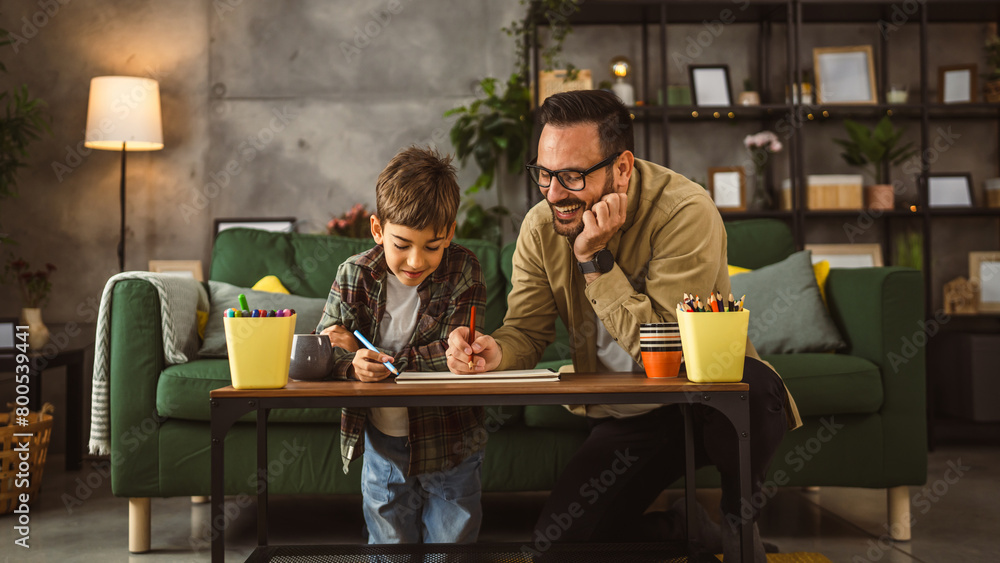 Father and son draw and paint together at home leisure activity Father and son draw and paint together at home leisure activity