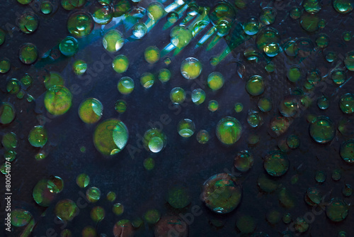  Drops of water of green color are located on a turquoise background. Abstract fantasy. 3D render.