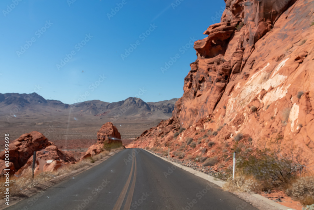 Panoramic view of endless winding empty Mouse tank road in Valley of Fire State Park through canyons of red Aztec Sandstone Rock formations and desert vegetation in Mojave desert, Overton, Nevada, USA Panoramic view of endless winding empty Mouse tank road in Valley of Fire State Park through canyons of red Aztec Sandstone Rock formations and desert vegetation in Mojave desert, Overton, Nevada, USA