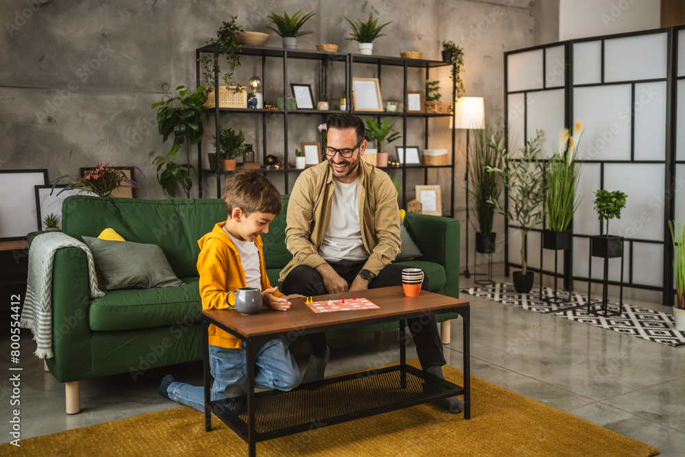 Father and son play board game together at home Father and son play board game together at home
