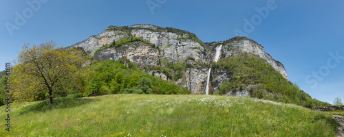 Large panorama of the Seerenbach Falls in spring with a green meadow and a blue sky photo