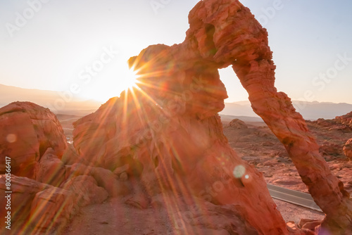Panoramic sunrise view of the elephant rock surrounded by red and orange Aztec Sandstone Rock formations and desert vegetation in Valley of Fire State Park in Mojave desert near Overton, Nevada, USA. photo