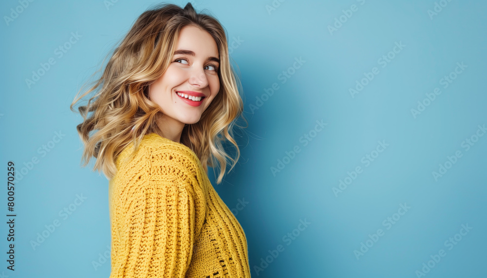 Happy young blonde-haired woman looking away against a blue background Happy young blonde-haired woman looking away against a blue background