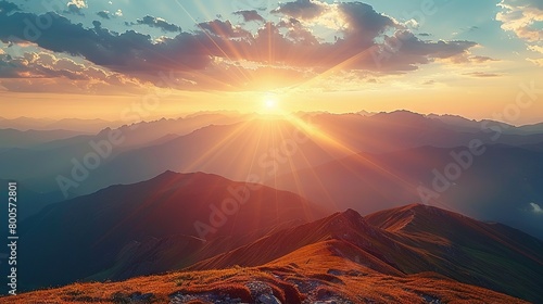   The sun illuminates the mountains afar as it ascends the peak photo