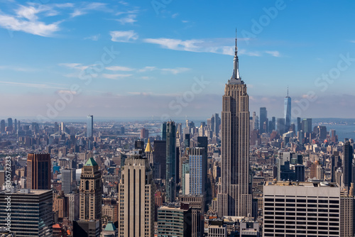 Vibrant urban skyline with towering skyscrapers and impressive architecture seen from Top of The Rock in New York. Empire State Building and One World Trade Center in the frame. Modern and lively city © Chris