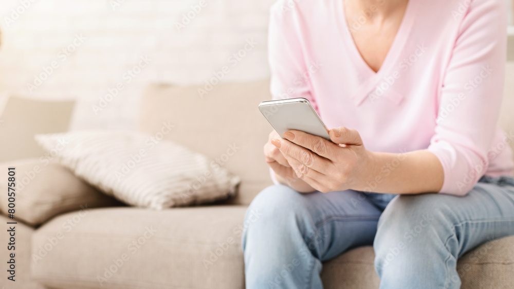 Cheerful aged woman using her smartphone at home Cheerful aged woman using her smartphone at home