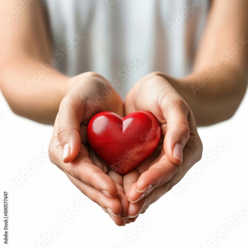 a person holding a red heart in their hands