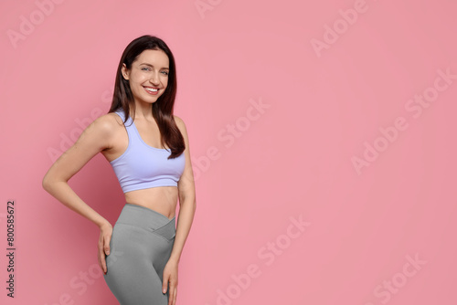 Happy young woman with slim body on pink background, space for text