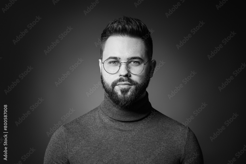 Portrait of handsome bearded man on dark background. Black and white effect