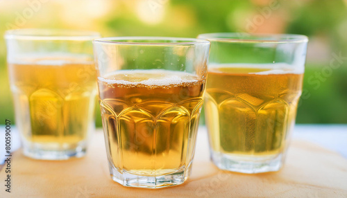 Close-up of glass of cider. Alcoholic beverage. Tasty drink. Blurred green background.