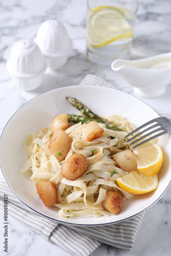 Delicious scallop pasta served on white marble table Delicious scallop pasta served on white marble table