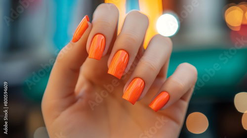 Mão de uma mulher com as unhas pintadas de laranja photo