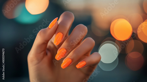 Mão de uma mulher com as unhas pintadas de laranja photo