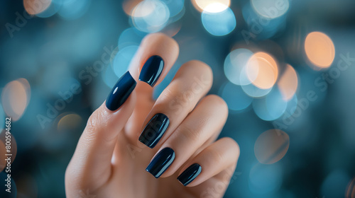 Mão de uma mulher com as unhas pintadas de azul escuro photo