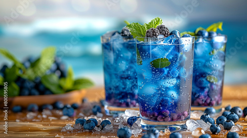 Three glasses of blueberry juice with ice cubes and mint leaves