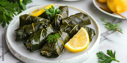 Dolma served on a white quartz background, Grape leaves stuffed with seasoned rice and herbs, Garnished with lemon wedges, turkish food photo