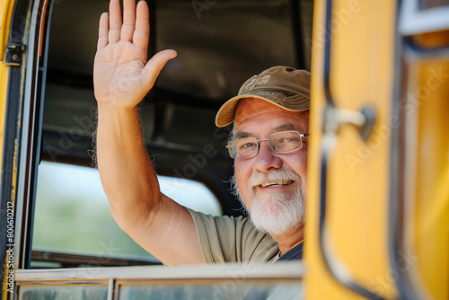 A school bus driver waves hello from the cab